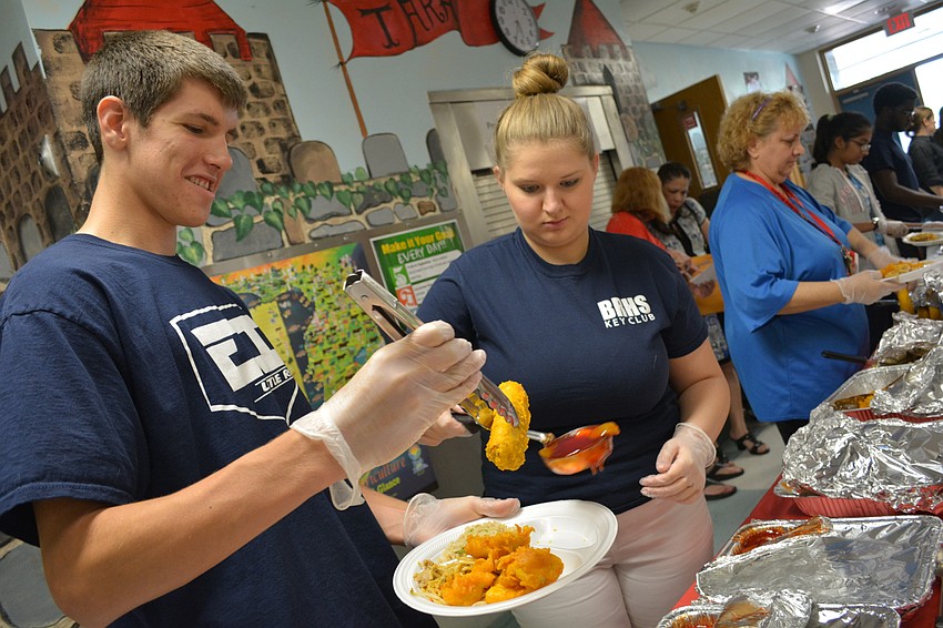 Braden River High's Easton Evans and Gina Burr dish out egg rolls.