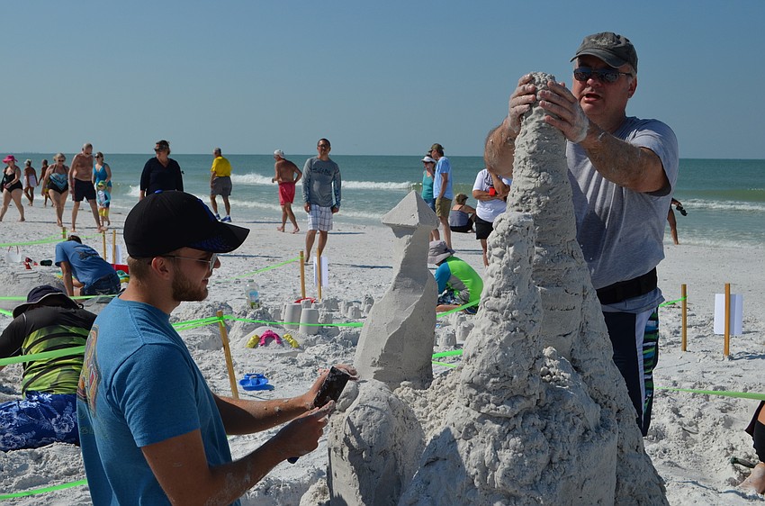 Returning Sand Sculpture champions Alec and Dave Muklewicz form the towers for their 