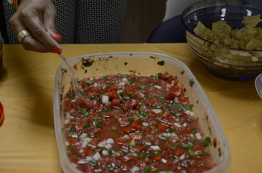 Prinicipal Shirin Gibson scoops up some pico de gallo styled salsa.