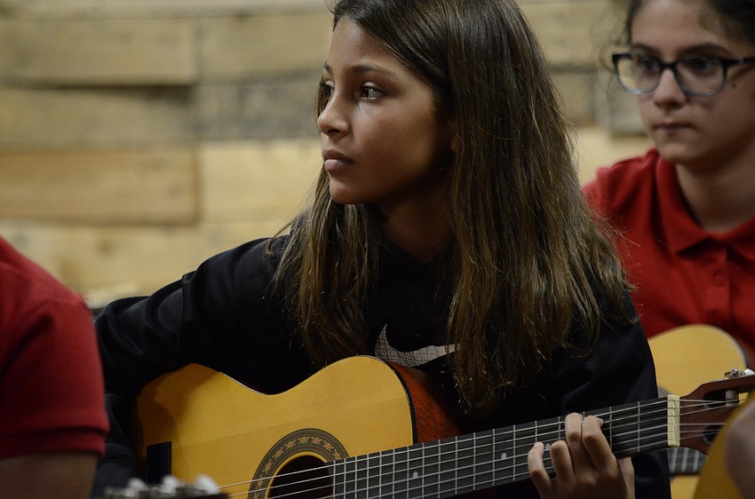 Julissa Garabito plays guitar during a song.