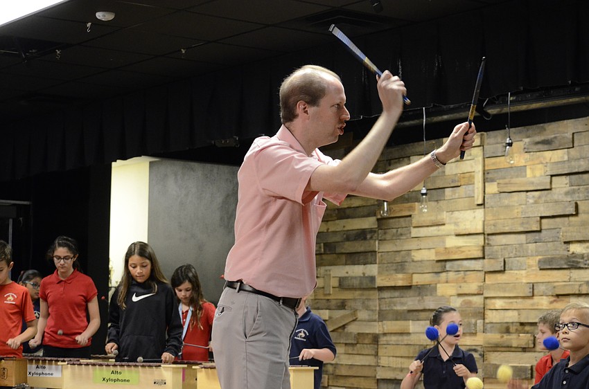 Music teacher David Katz sets the beat by smacking drumsticks.