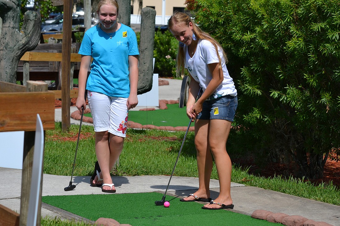 Kelly Senchyshak watches as her sister Kyra putts during the 2015 Tee up for Sea Turtles with Turtle Inc.