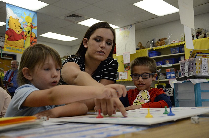 Kaitlyn Alvarez plays a game with Lilly Achille and Vincent Charette.