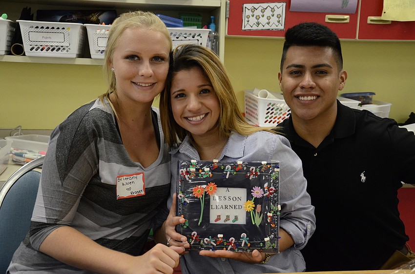 Brittany Kluen, Jessica Martinez and Julio Martinez read a Christmas-themed story.