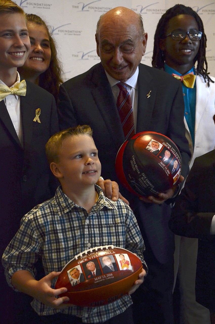 Dick Vitale pats the shoulder of Joshua Fisher, a pediatric cancer survivor from Tampa.