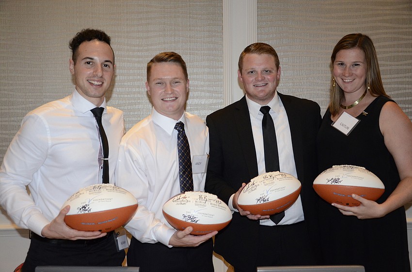 Volunteers Adam Haber, Andy Embody, Tyler Hagan and Caitlin Callaghan hand out autographed footballs and basketballs for donations.