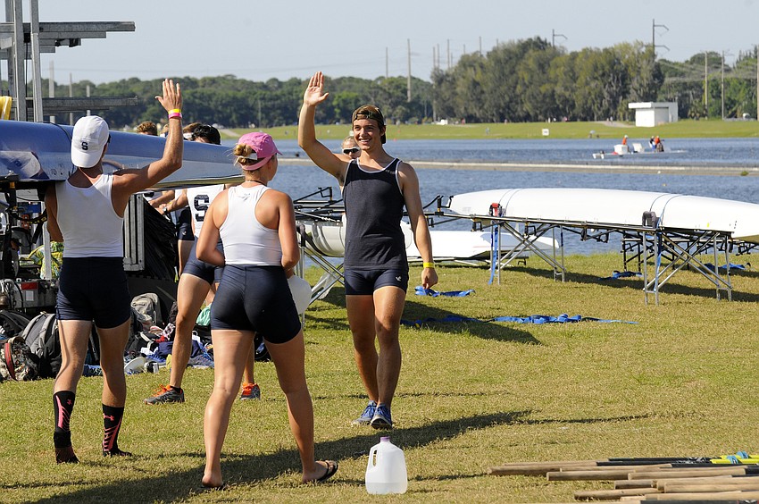 Jaime Velez, right, congratulates Trey Whitten and Lydia Bremer after watching the Men's Lightweight 4+ qualify for the national championships.