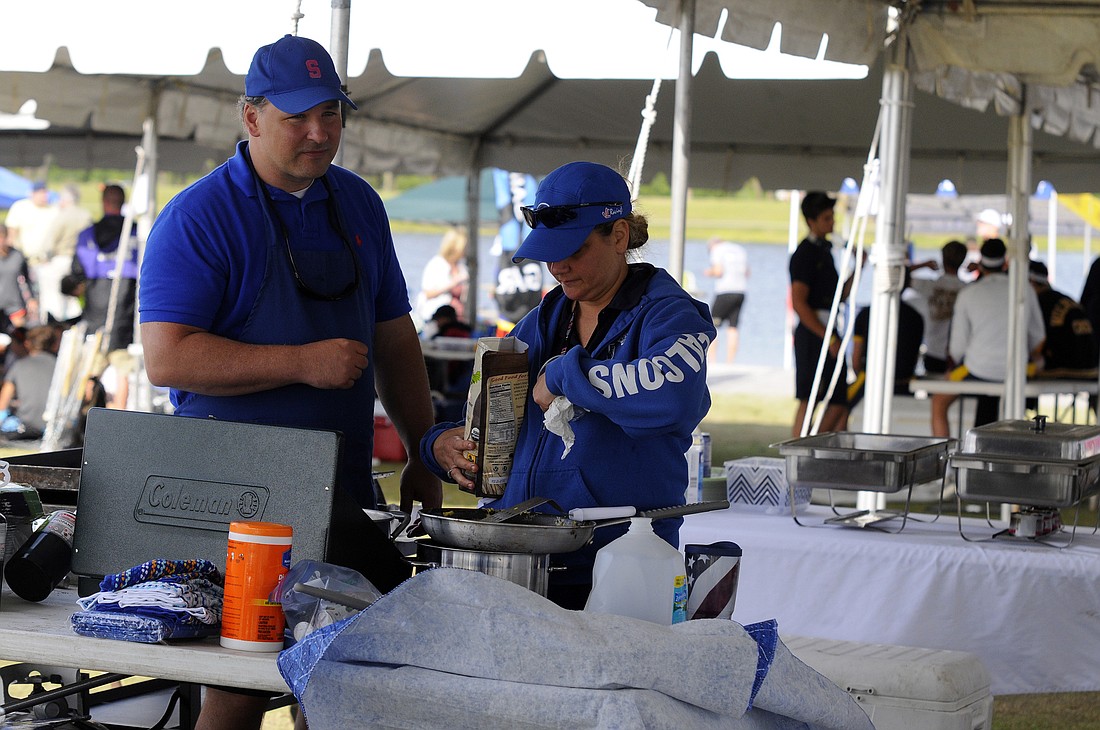Sarasota residents Marc and Dawn Bukaty prepare homemade chipotle bowls for roughly 180 Sarasota Crew rowers.