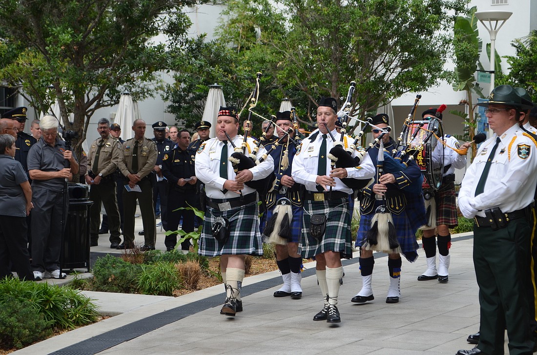 Members of the  Guns n Hoses Pipes n Drums of Southwest Florida march through the Sarasota Memorial Hospital courtyard.