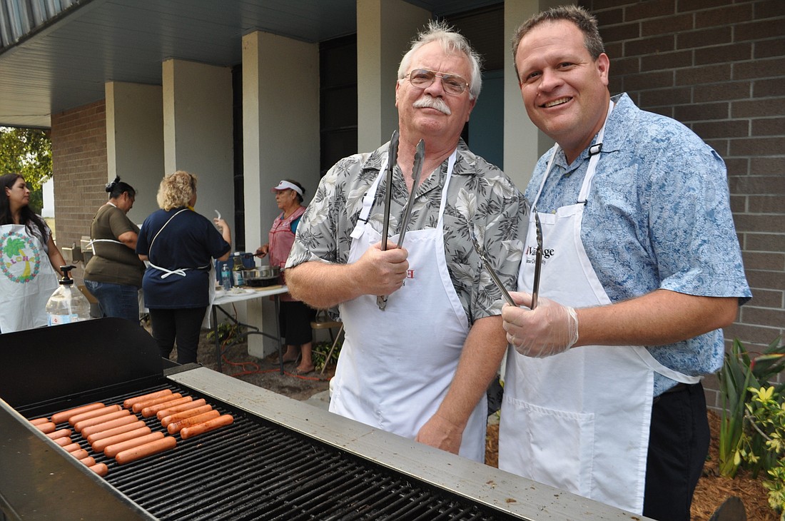 Sid Royce joins his son, Tara Elementaryâ€™s Principal Steve Royce, grill hot dogs together for Tara families to enjoy during a school luau last year. File photo