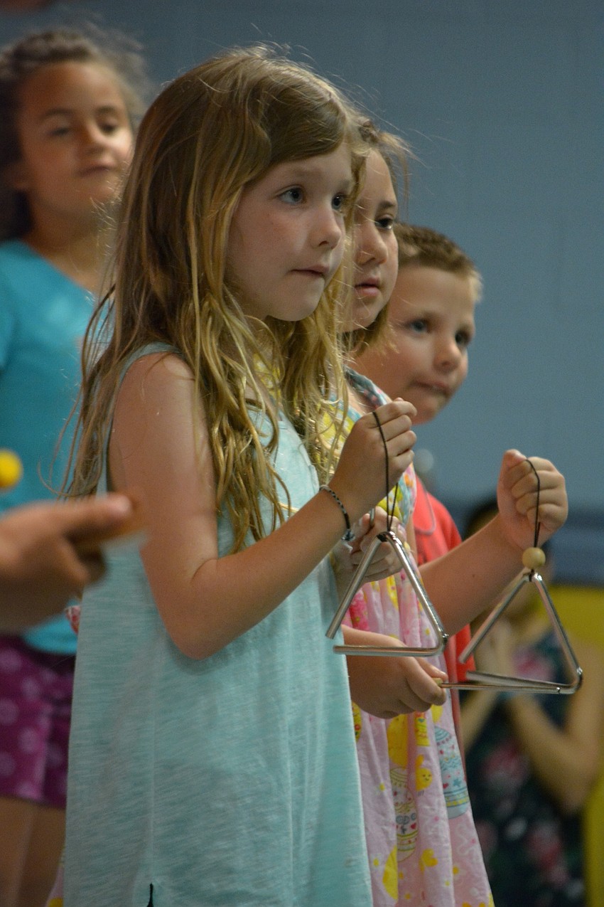 Brinlee Johnson chimes for thunder and lightning during a song.