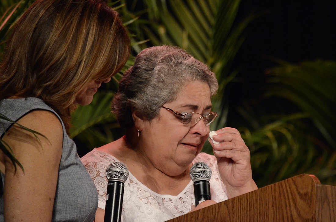 Laraine Batista, right, wipes away a few tears during her speech. Batista is bilingual; however district translator Michelle Gomez-Raney translated her speech into Spanish for the audience.
