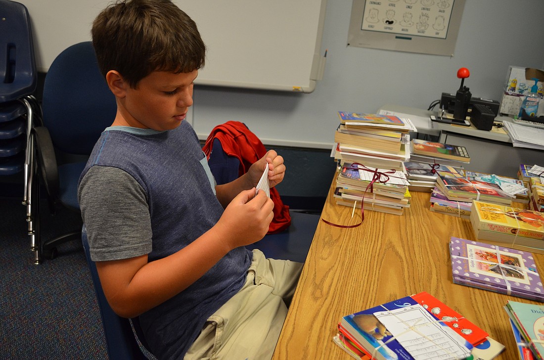 Jack Bates helps tie up packages of books to be delivered to Emma Booker Elementary School.