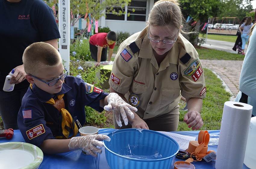 Christine Austin helps her son, Trevor, make slime for Cub Scout Troop 191.