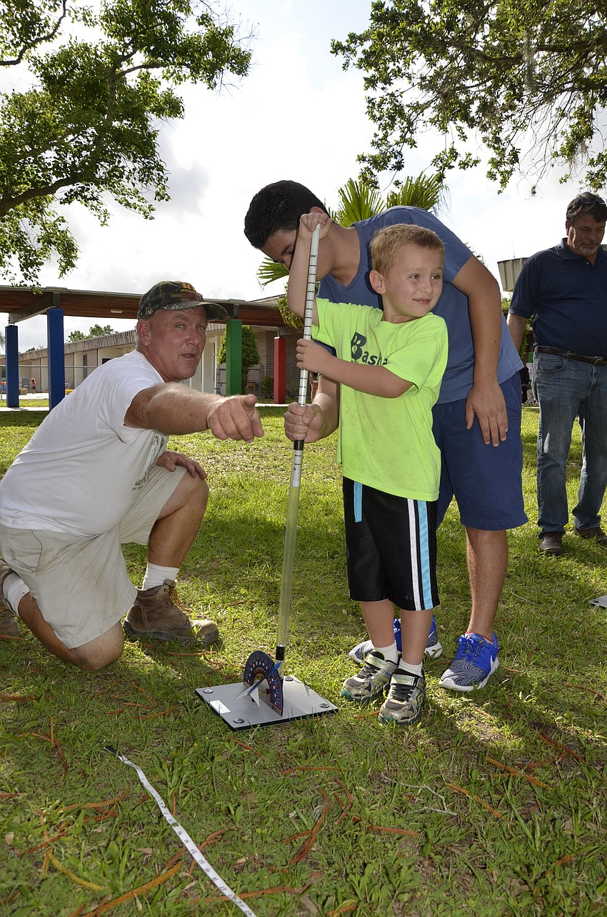 Paul Mason, Nicholas Mason and Jamal Allan of Braden River High School launch a straw rocket.