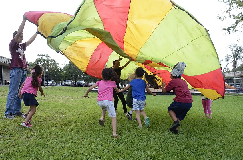 Students play under the parachute.