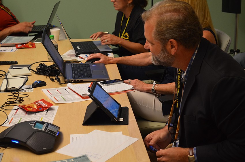 Assistant Town Manager Michael Hein receives a scenario from Deputy Fire Chief Sandy Drake.