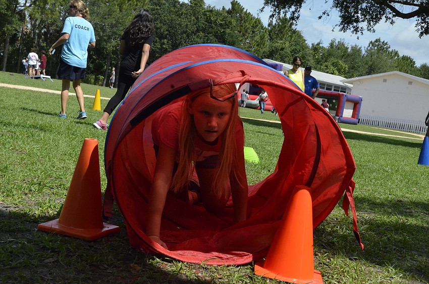 Mackenna Bradley crawls through a tunnel on the way to her next game.