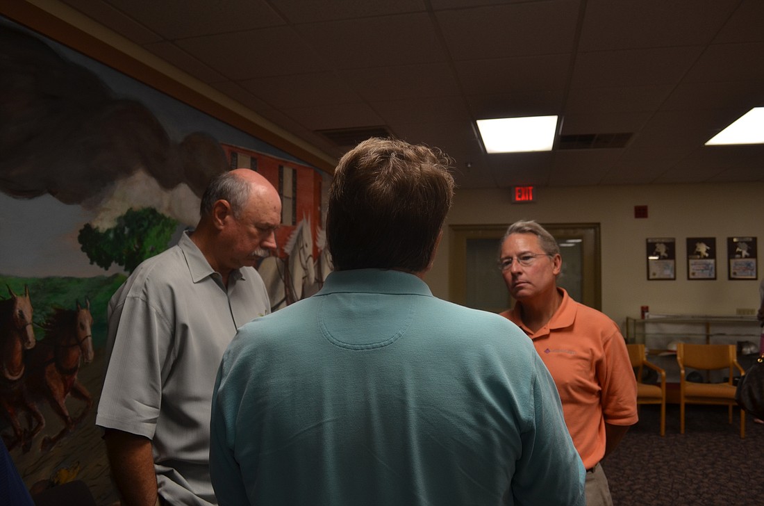 City utilities director Mitt Tidwell and McKim and Creed Project Manager Robert Garland discuss plans for Lift Station 87 with a Hudson Bayou resident.