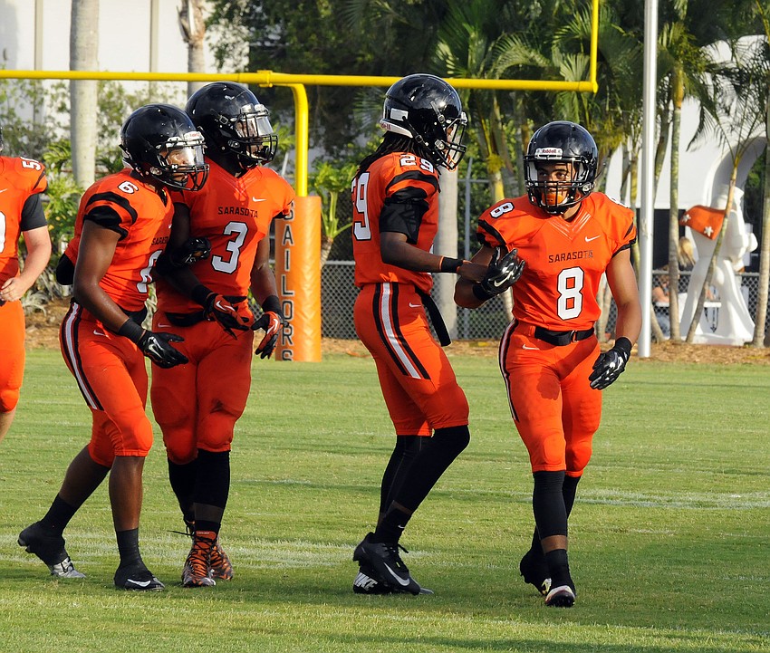 Sarasota linebacker Kenny Turner, No. 8, is congratulated by Isaiah Priester, Dekota Morris and Tarone Jackson following a defensive stand.