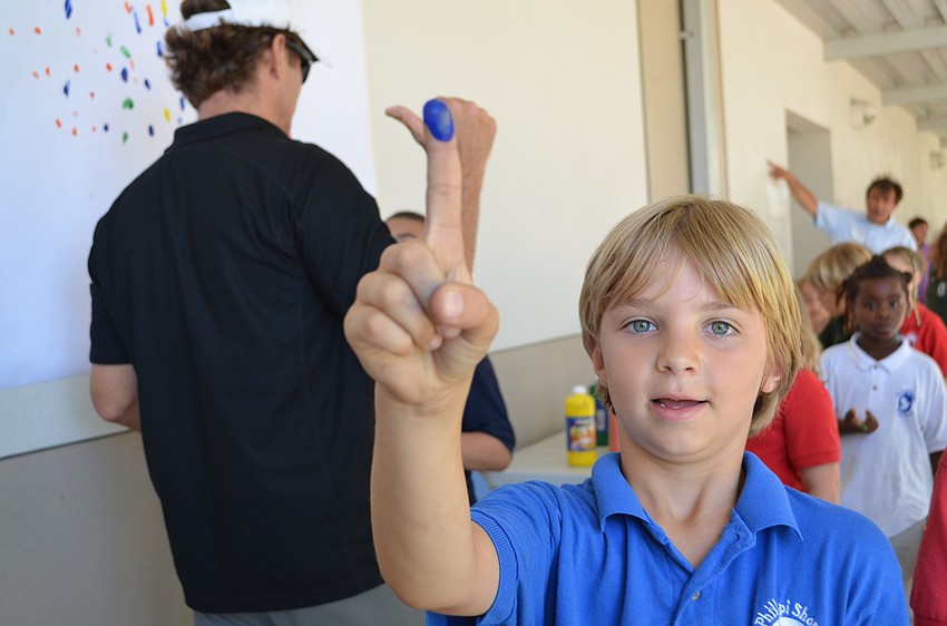Emmett Russo shows off his blue finger that he painted for the high jump event.