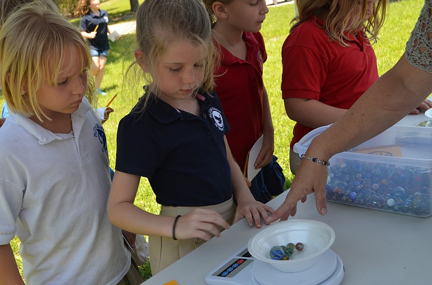 Kylin Rice weighs a bowl of marbles.