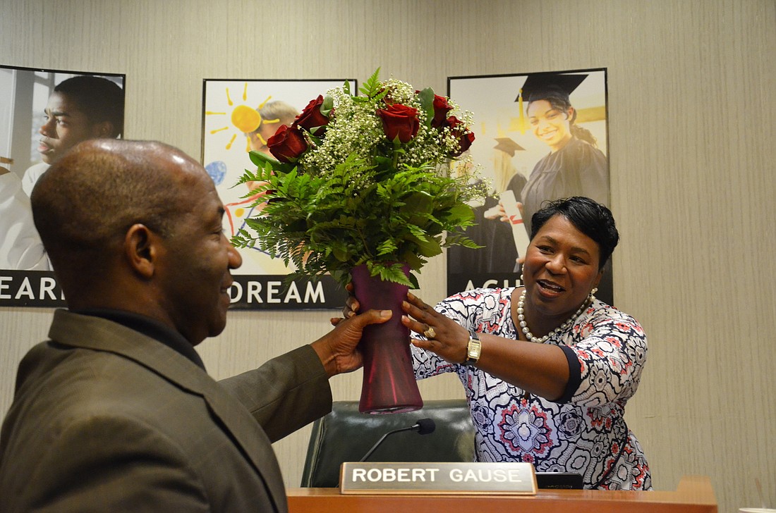 Superintendent Diana Greene accepts flowers from her husband, James, after the Manatee County School Board approved her 4-year contract.
