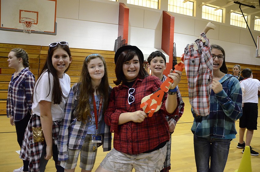 Ashley Zeitz, Tessa Mayfair, Izzy Rines, Will King and Izzy Tracy wield the plaid team flag.