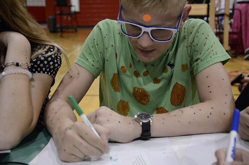 Matthew Gagnemi works with his team at mental math tic-tac-toe.