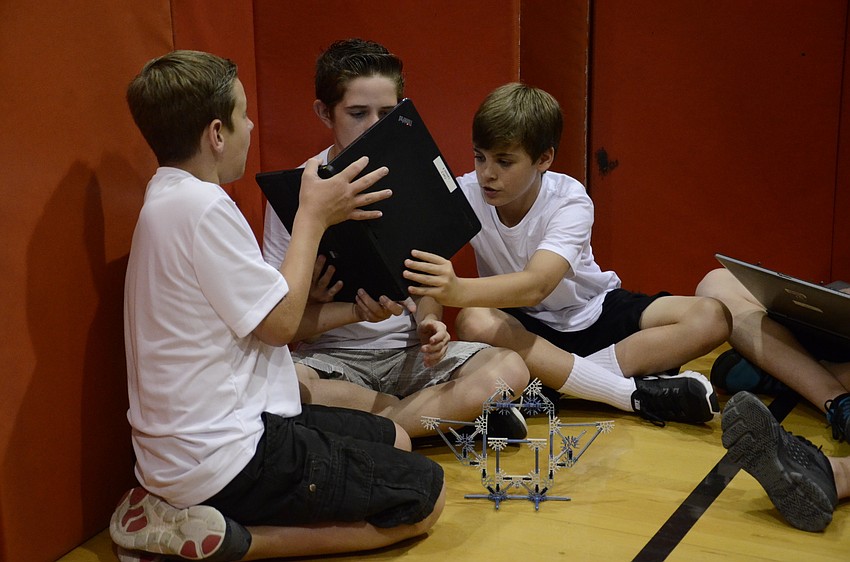 Nathan Parker, Jeremy Golsey and Jacob Jackson relay messaged to their teammates outside the wall about how to build the object.