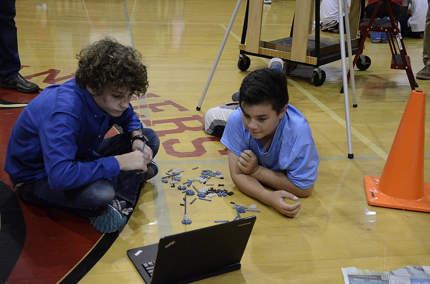 Kolby Wade and Sam Phillips wait for instructions from their teammates to learn how to build the object.