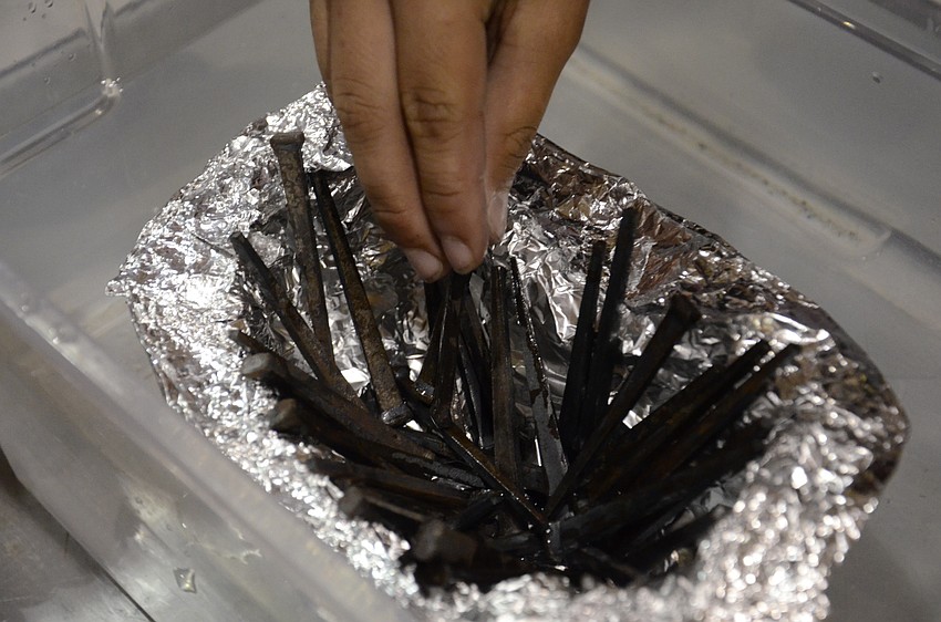 Lucas Naylor carefully places the last of 39 nails which his team's boat successfully kept afloat.