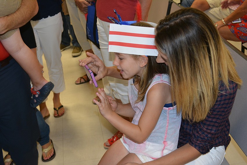 Ryleigh Baker gets to Skype with her dad, Army Sgt. Joe Baker, who is deployed to the Middle East, after her concert at Gene Witt. She is held by mom, Brittany Baker.