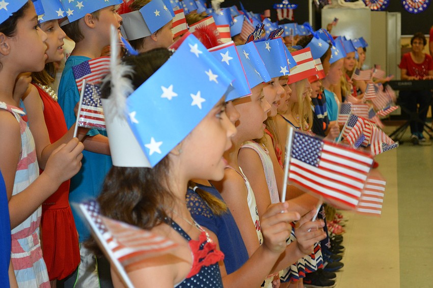 Charlize Norman-Terrazas waves her flag during a song..