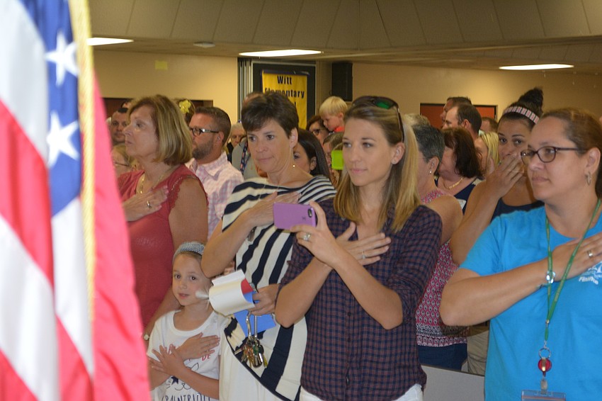 Brittany Baker connects with deployed husband Sgt. Joe Baker using Skype during the Star Spangled Banner.