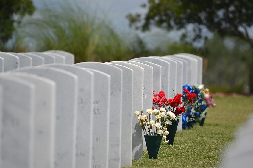 Red, white and blue bouquets adorn the grave sites at Sarasota National Cemetery.
