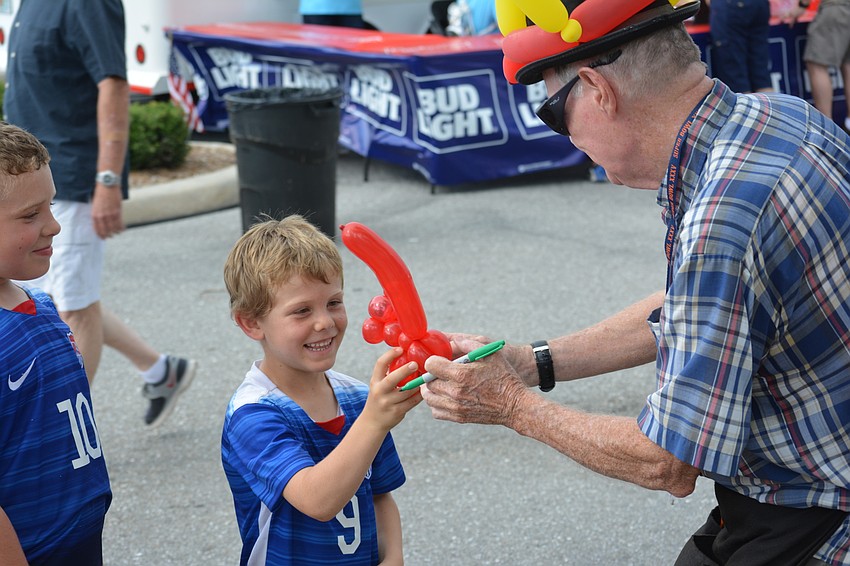 Ryan Rowe, 5, of Sarasota gets a monkey balloon from Peridia's Stevie Dee.
