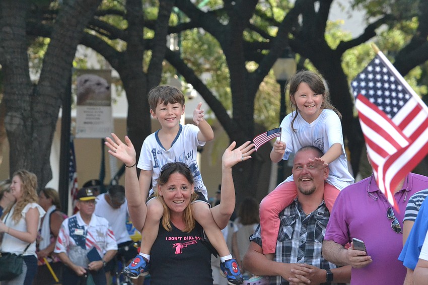 Nathaniel and McKenzie hitch a ride on the shoulders of Bridgette and Paul Goldberg to get a better view of the parade.