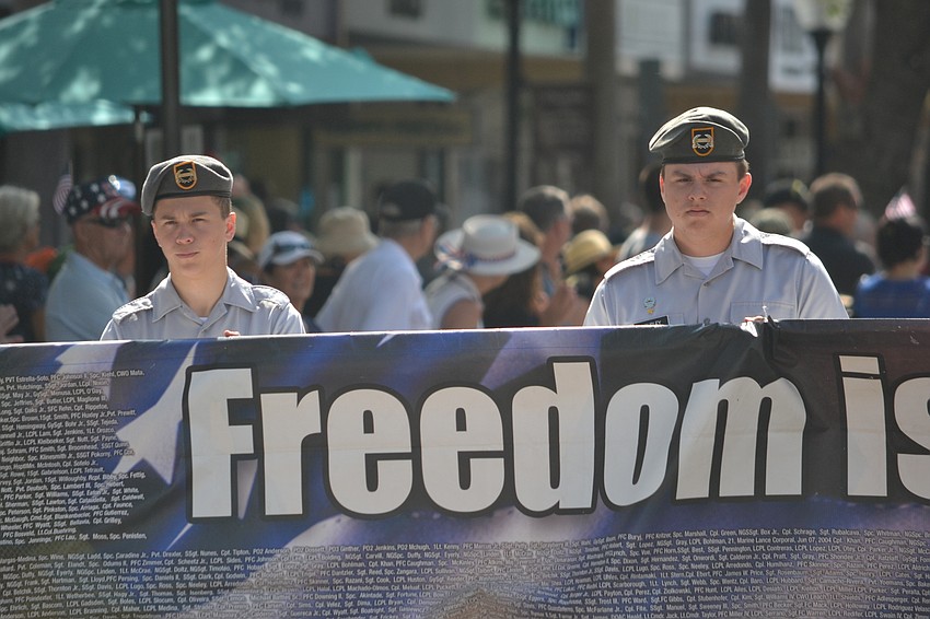 Sarasota Military Academy cadets hold the banner with names of members of the military who have died while serving.