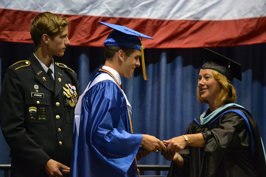 Brandon Miller receives his diploma from Sarasota Military Academy Executive Director Christina Bowman.