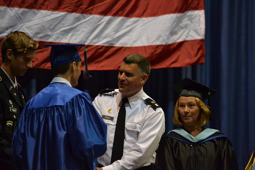 SMA Captain Mike Friday presents his son Michael Friday with his diploma.