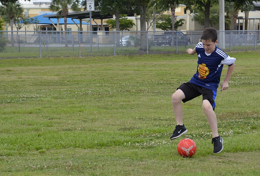Sam Leavy tries to keep the ball away from his classmates and score a goal.