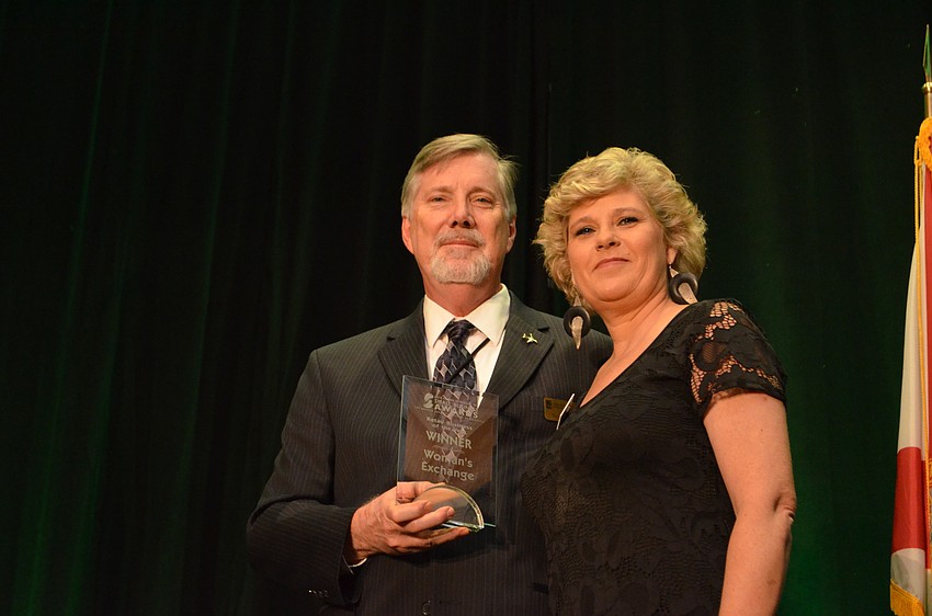 Martin Lange gives Women's Exchange CEO Karen Koblenz the award for Retail Business of the Year.