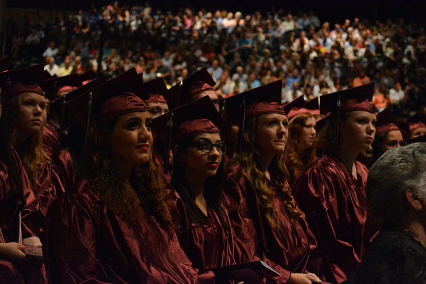 Graduates listen to commencement speakers and watch a video of photographs of the Class of 2016.