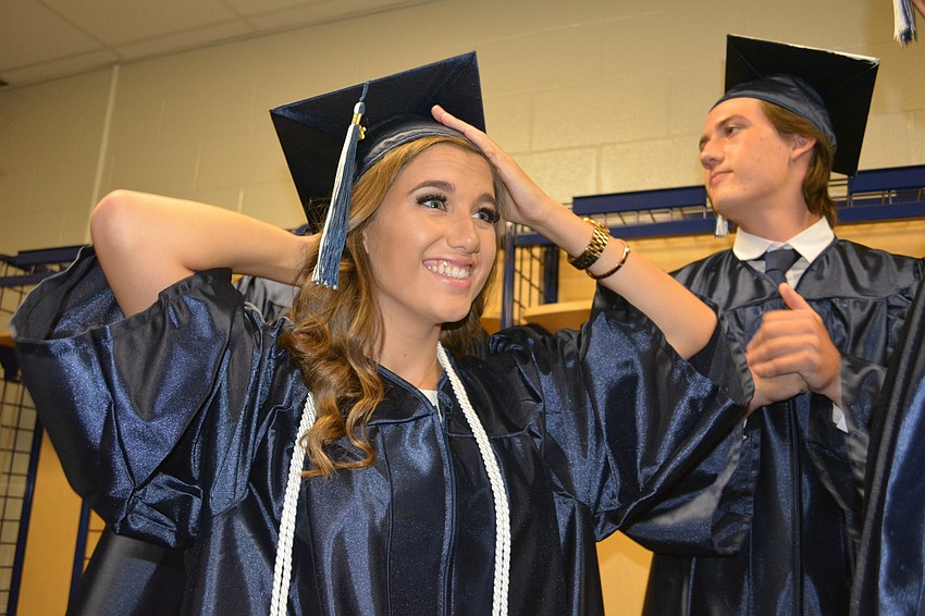 Libby Grimond chuckles as her friend Jon Eichenbaum, not pictured, sing's the school's alma mater.
