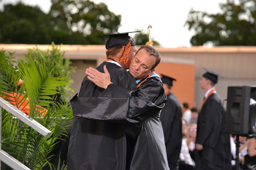 Nathan Buckingham hugs principal Jeff Hradek after accepting his diploma.