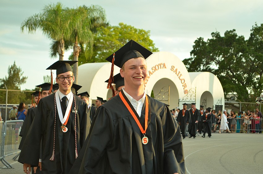 Seniors enter the Charlie Cleland Stadium to start the commencement ceremony early.