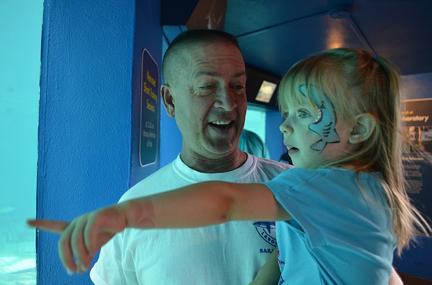 Charlotte Winemiller asks her father Jim to name the sea life swimming in the tank.