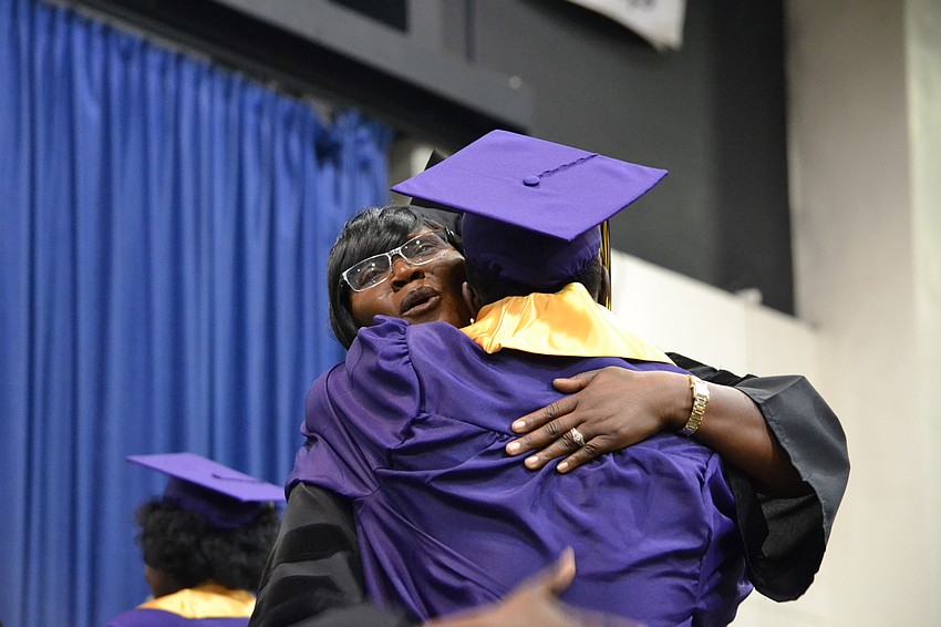 Booker High School Principal Rachel Shelley embraces Bill Jackson on stage.