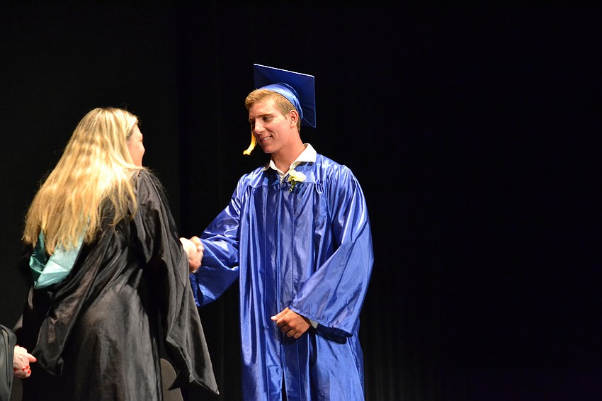 Pine View senior class sponsor Robin Melton congratulates Stone Barcomb.